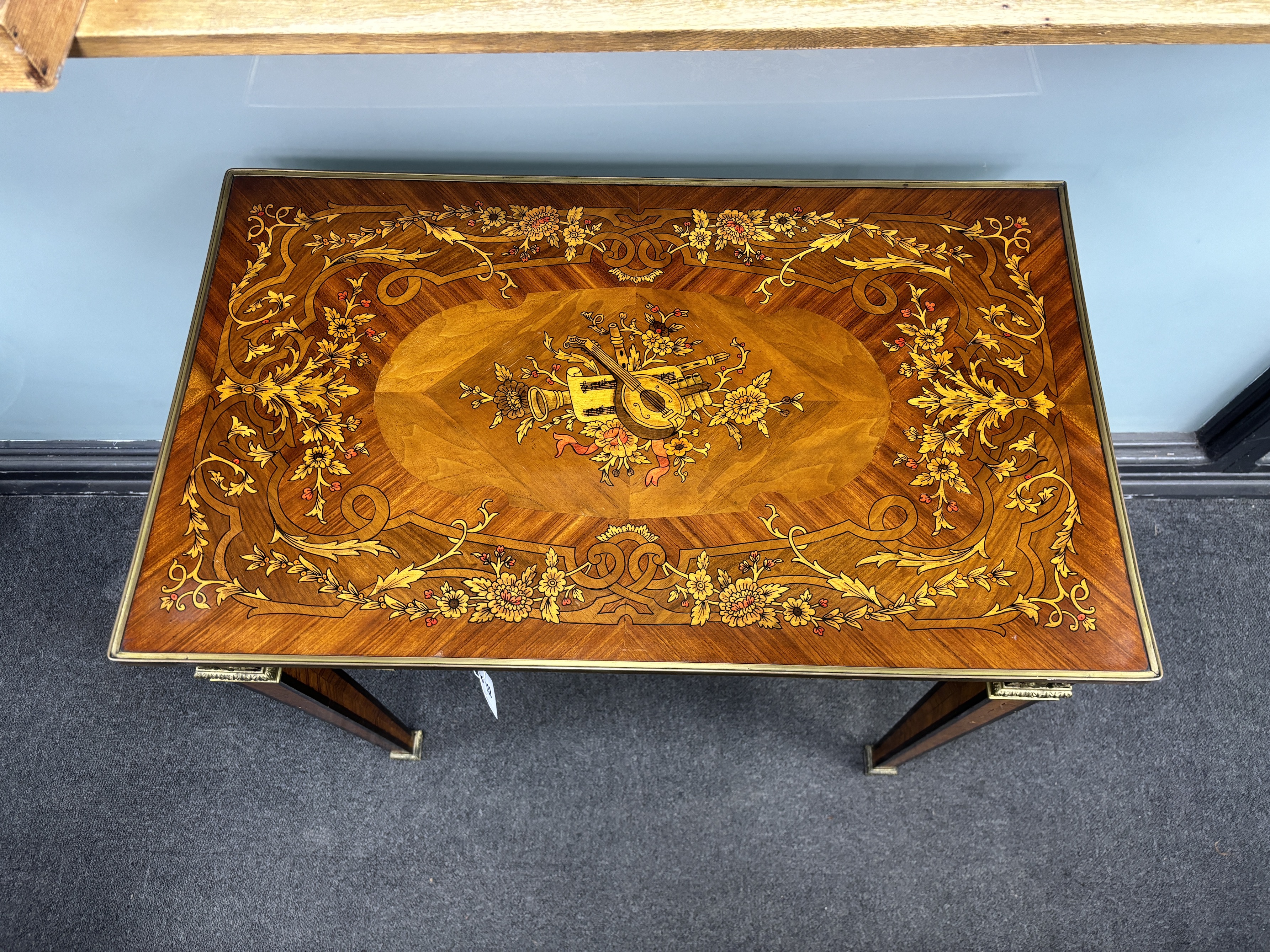 A Louis XVI style floral marquetry side table, the top inlaid with a musical trophy, width 80cm, depth 47cm, height 78cm